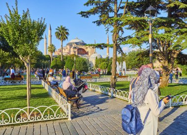 Istanbul, Türkiye - 8 Temmuz 2018. Vatandaşlar Ayasofya Sophia cami içinde belgili tanımlık geçmiş ile Sultanahmet parkta güneşli bir zevk. Istanbul, Türkiye.