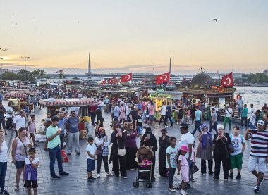Istanbul, Türkiye - 7 Temmuz 2018. Görüntüleyiciyi Eminönü İskelesi balık Haliç koya bakan batımında fotoğraf çekme vatandaşlar tekneler ve Haliç Köprüsü arka planda sandviç. Istanbul, Türkiye.
