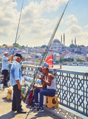 Istanbul, Türkiye - 11 Temmuz 2018. Galata vatandaşlarını Golden Horn Bay ağız ve Eminönü İlçe siluetinin manzarasına balıkçılık ile Süleymaniye Camii içinde belgili tanımlık geçmiş köprü. Istanbul, Türkiye.