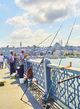 Istanbul, Türkiye - 11 Temmuz 2018. Galata vatandaşlarını Golden Horn Bay ağız ve Eminönü İlçe siluetinin manzarasına balıkçılık ile Süleymaniye Camii içinde belgili tanımlık geçmiş köprü. Istanbul, Türkiye.