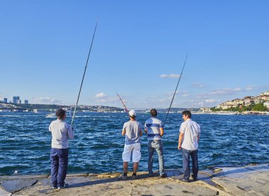 Istanbul, Türkiye - 11 Temmuz 2018. Arka planda Boğaziçi Köprüsü ile Boğaz'da balık tutma vatandaşlar. Istanbul, Türkiye.