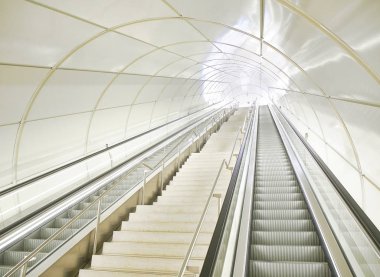 Modern bir yeraltı Metro istasyonunun bir tünelde yürüyen merdiven.