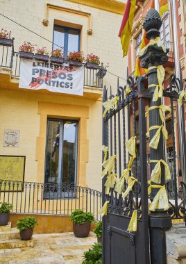 Begur, İspanya - 15 Eylül 2018. Katalonya bağımsızlık hareketinin hapisteki liderlerine desteğinde sarı kurdeleler balkonda ücretsiz siyasi tutsaklar diyor bir afiş Begur şehir salonu kapısı süslenmiş. Girona, Costa Brava,