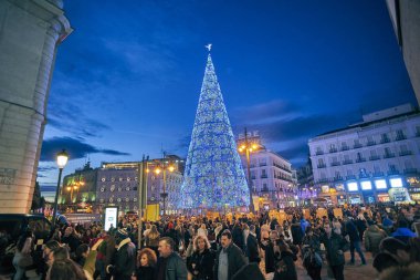 Madrid, İspanya - 1 Aralık 2018. Puerta del Sol kare, Noel ışıkları ve parlak Noel ağacı tarafından aydınlatılmış gece. Calle de Carretas sokaktan görüntülemek.