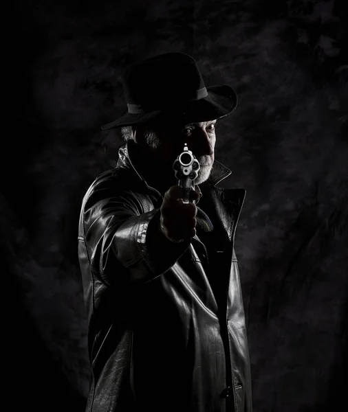 黒いテクスチャ背景の前でビンテージ リボルバーで武装した古い私立探偵 — ストック写真