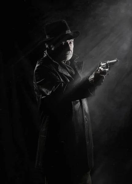黒いテクスチャ背景の前でビンテージ リボルバーで武装した古い私立探偵 — ストック写真