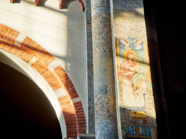 Milan, İtalya - 29 Aralık 2018. Güneş Sant'Ambrogio Basilica NEF duvarlarda fresk aydınlatıcı bir ışın. Milan, Lombardiya, İtalya.