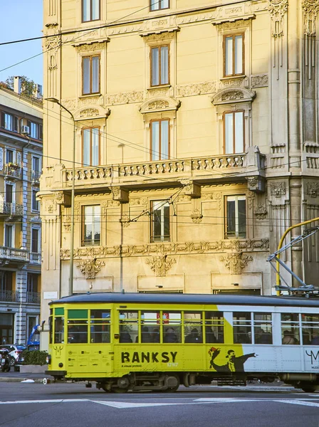 A tram advertising a monographic exhibition of Banksy crossing Via Giovanni Boccaccio. Milan, Lombardy, Italy. — Stock Photo, Image