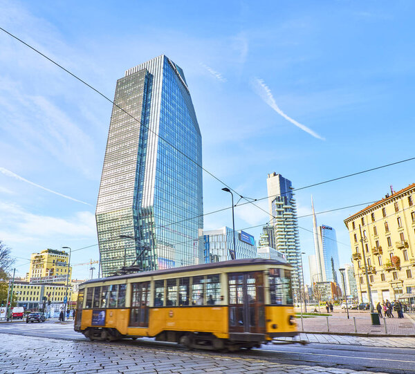 Milan, Italy - December 30, 2018. A tram crossing Porta Nuova Business district with the Diamond Tower in background. View from Piazza San Gioachimo square. Milan, Lombardy, Italy.