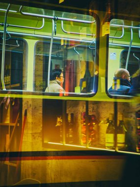 Milan, İtalya - 29 Aralık 2018. Milan oryantal bir erkeklerde geceleri taşıma tramvay. Lombardy, İtalya. Bir bar mağazası yansıma yoluyla görüntüleme.