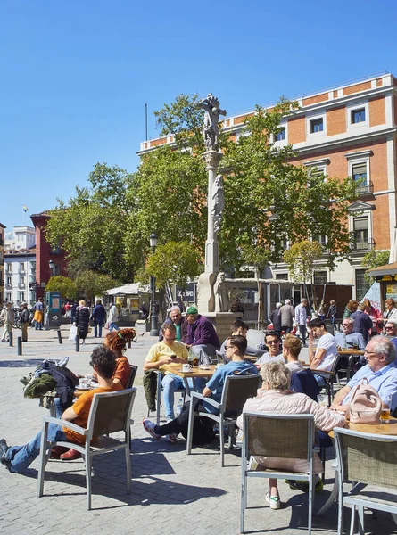Gente refrescante en una terraza en la plaza Jacinto Benavente de Madrid, España . — Foto de Stock
