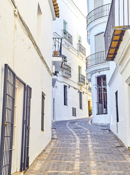 A typical street with whitewashed walls of Vejer de la Frontera downtown. View from the Jose Castrillon street. Cadiz province, Andalusia, Spain.