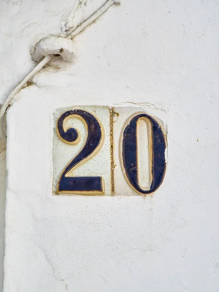 Carrelage céramique antique numéro 20 sur un mur blanchi à la chaux . — Photo