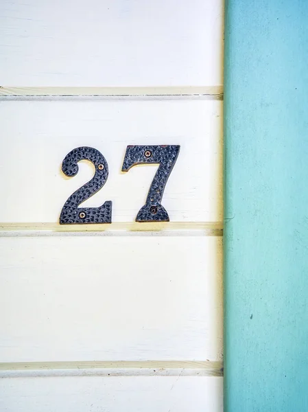 Vintage iron number 27 on a wooden wall. — Stock Photo, Image