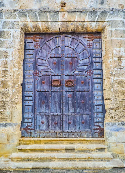 An Arab wooden door of a Mosque with the shape of Horseshoe arch