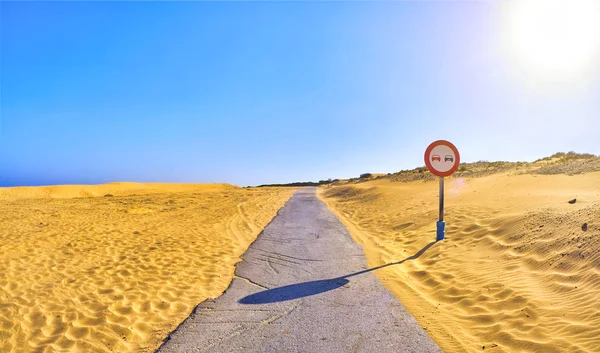 Une route traversant un terrain de dunes arides avec un panneau Aucun dépassement . — Photo
