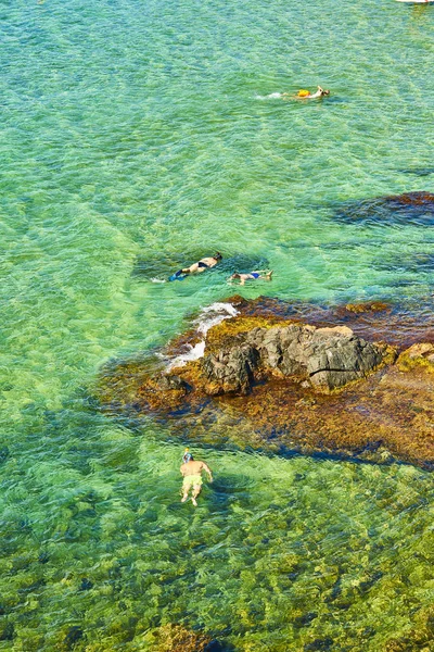 Toeristen snorkelen in een turquoise zee. — Stockfoto