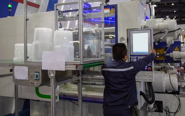 Arbeiter betätigt Kunststoff-Spritzgießmaschine — Stockfoto