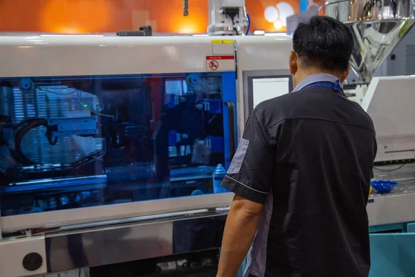 işçi plastik enjeksiyon kalıplama pres makinesi çalışır