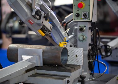 Bant testeresi boruları kesiyor. Sanayi makineleri