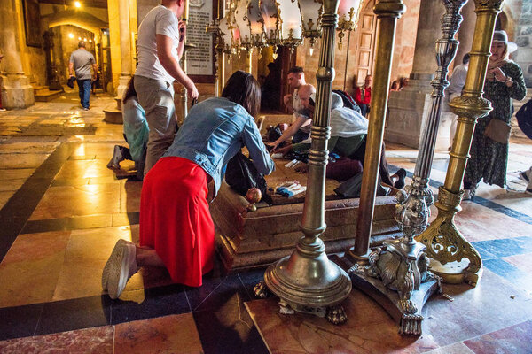 ИЕРУСАЛИМ - 15 мая 2018 года: Паломники, поклоняющиеся Камню Соборования, месту, где было положено тело Иисуса, после распятия. Храм Гроба Господня
