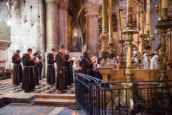 JERUSALEM, ISRAEL - MAY 15, 2018: Franciscan monks praying in the front of Jesus tomb in the Church of the Holy Sepulchre