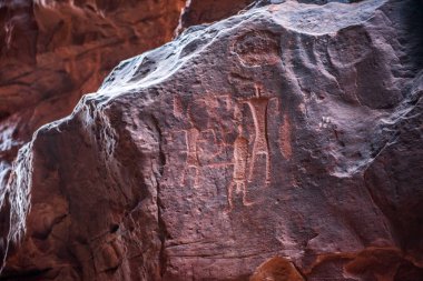 Deve kervan ve insanlar temsil eden kaya antik Nabatean ve Thamudic yazıtları. Khazali Kanyon, Wadi Rum çöl, Jordan