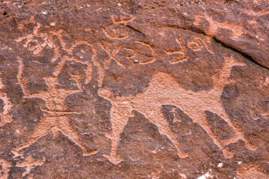 Anfashieh tarih öncesi yazıtlar ve taş bir duvara petroglyps. Wadi Rum, Jordan Nabatean ve Thamudic dönemde deve kervanı gösteren kaya resimler