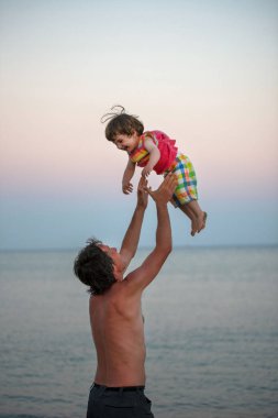 Kalite zaman ebeveynlik, babalık kavramı. Babası onun bebek kız plajda hava atma
