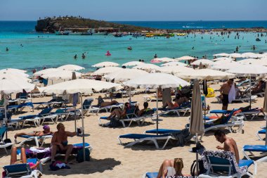 Nissi Beach, Ayia Napa, Kıbrıs - 15 Haziran 2017: Turist rahatlatıcı tatil yaz sahilde. Nissi beach Kıbrıs en ünlü plaj beyaz kum ile