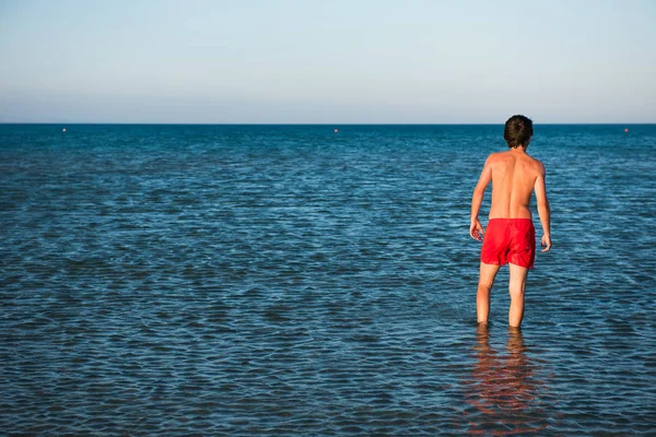 Štíhlý Chlap Pózuje Červené Plavky Mořské Vodě Koncept Parodie — Stock fotografie