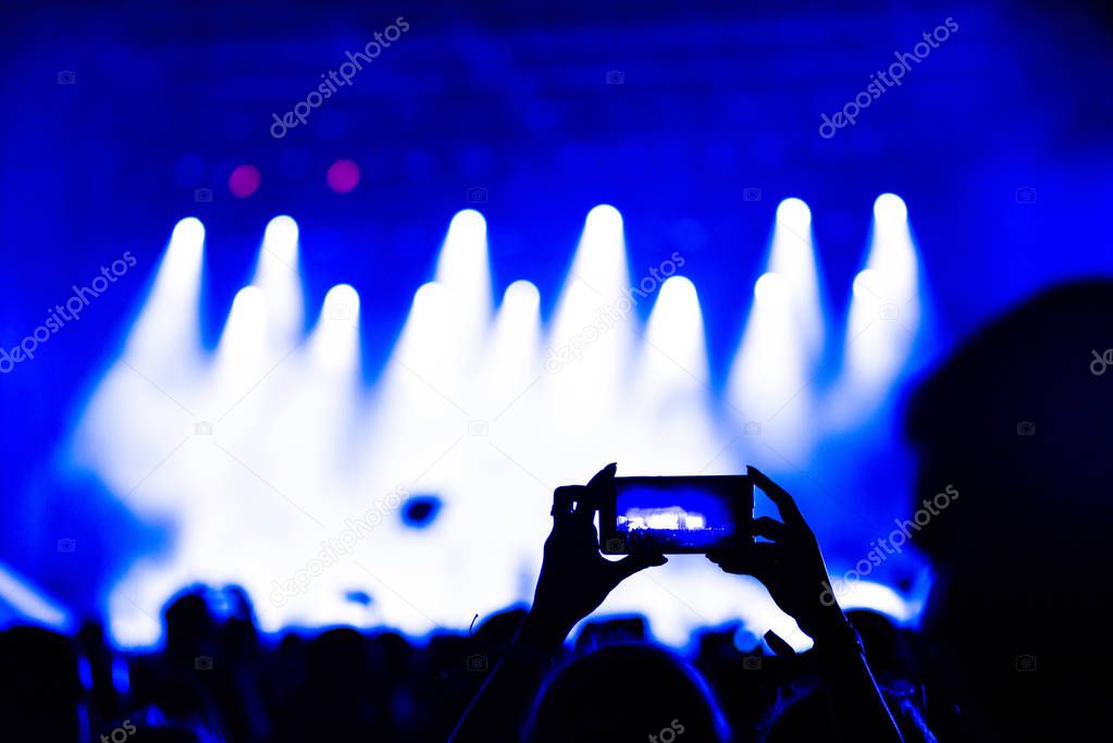 People taking photographs with touch smart phone during a music concert