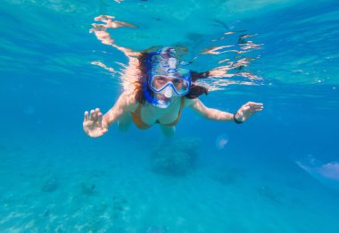 Sualtı çekim tropikal deniz mercan resif üzerinde içinde şnorkel genç bir kadın. Kız jellyfishes ile yüzme