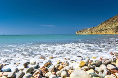 Turkuaz deniz su ve çakıl taşları ile pastoral sakin tropikal plaj