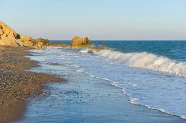 Beyaz dalgalar çökmesini karşı bir kayalık plaj