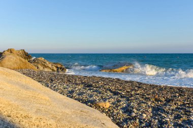 Beyaz dalgalar çökmesini karşı bir kayalık plaj