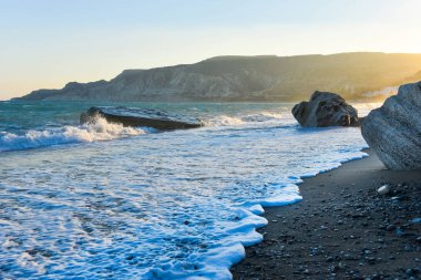 Beyaz dalgalar çökmesini karşı bir kayalık plaj