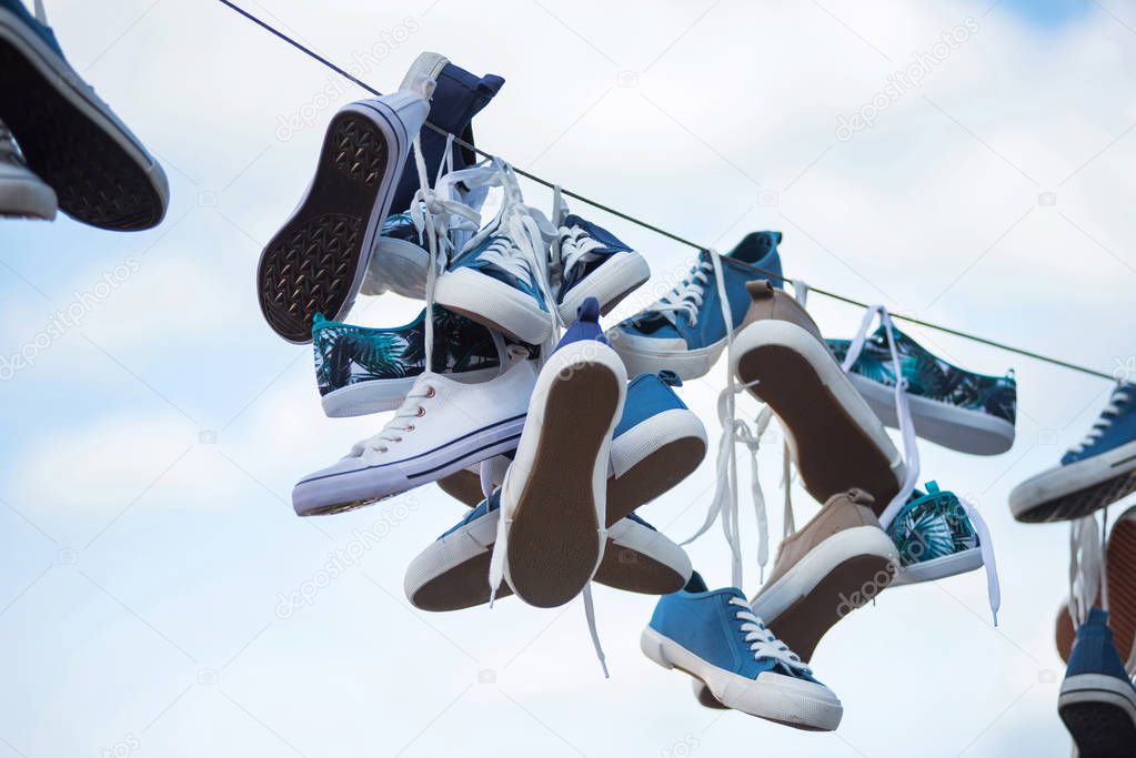 Pairs of sneakers and shoes hanging on a rope