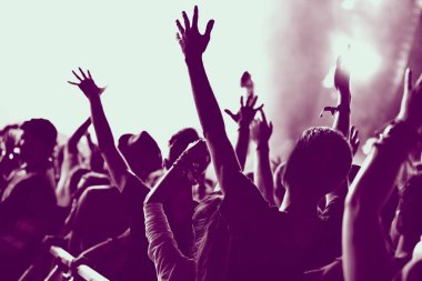 Kalabalık konser uzanmış kolları olan mor filtre uygulanmış, arka görünümü