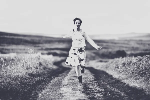 スカートの中の田舎道を実行している女性 自由の概念 黒と白のトーン ヴィンテージ効果 — ストック写真