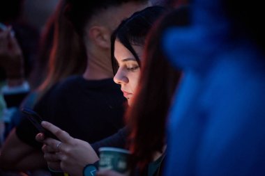 Bontida, Romanya - 18 Temmuz 2018: elektrik kale Festivali canlı bir konser sırasında akıllı telefonunu kontrol bir genç kız