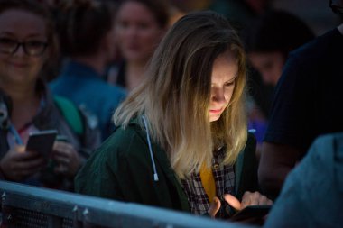 Bontida, Romanya - 18 Temmuz 2018: elektrik kale Festivali canlı bir konser sırasında akıllı telefonunu kontrol bir genç kız