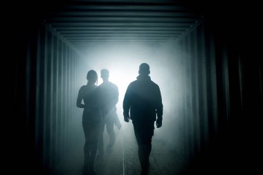 Tünelin sonunda ışık. İnsan silüeti yeraltı koridorda puslu