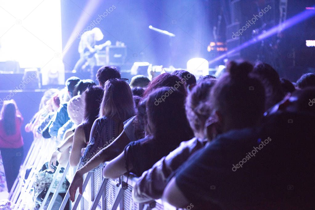 Crowd at concert, cheering crowd in front of bright stage lights