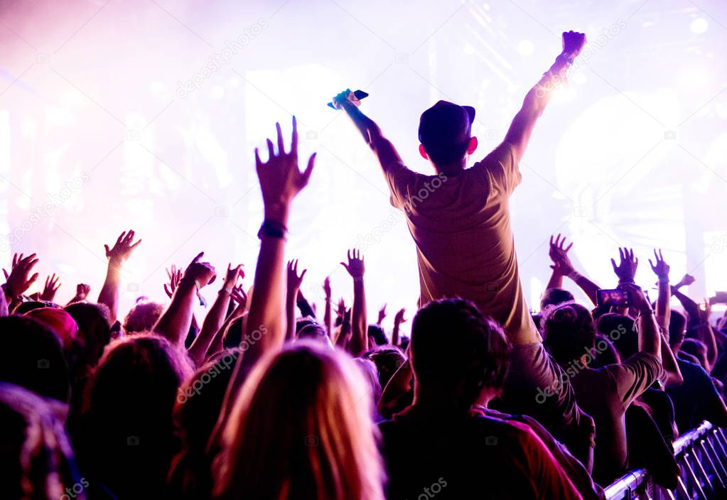 Silhouette of concert crowd in front of bright stage lights