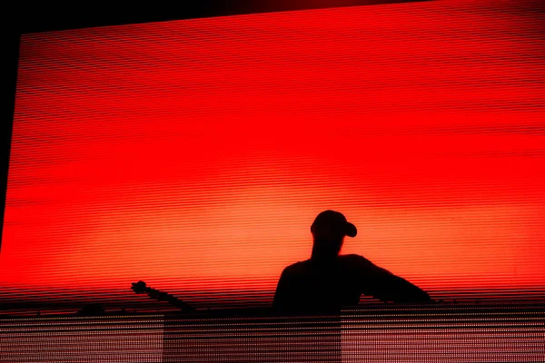 Silhouette Eines Discjockeys Mischt Live Auf Rotem Hintergrund — Stockfoto