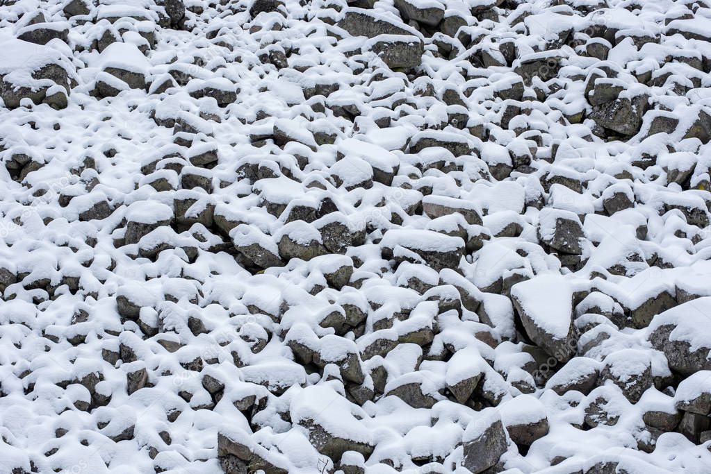 Scree slope, debris, stones covered with snow in the mountains