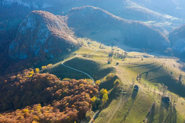 茅葺き ルーマニア トランシルバニアの未舗装の道路と秋の田園地帯山の風景の空中ドローン シーン — ストック写真