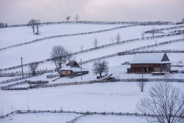 Romanya 'nın Transilvanya kentindeki Alp köyü. Kışın karla kaplı evler