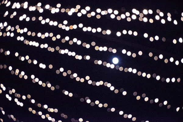 クリスマス都市ライトの背景のボケ味を抽象化します 暗いパターン上のぼやけ 明るい輝く円 — ストック写真